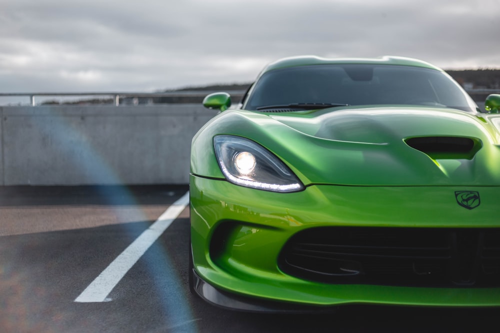 selective-focus of green sports car parked under white sky