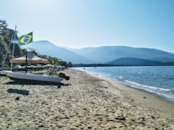 The peaceful beach of Praia do Viral with a lancha approaching the shore.
