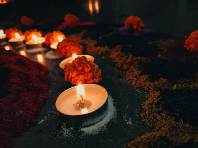 A polished aarsi reflecting soft candlelight, surrounded by marigold flowers.
