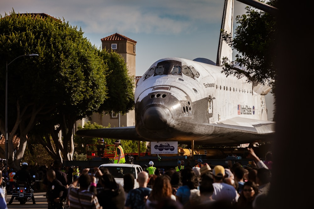 a crowd of people watching a space shuttle on display