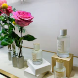 An elegant display of single attar bottles like Royal Attar and Ruh De Santal on a wooden surface.
