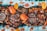 A vibrant and colorful seafood feast is displayed, featuring large crabs, shrimp, and mussels surrounded by rice and garnished with sliced mangoes and watermelon. Various grilled meats and a dish of dipping sauce are arranged on wooden platters, creating an inviting and appetizing arrangement.