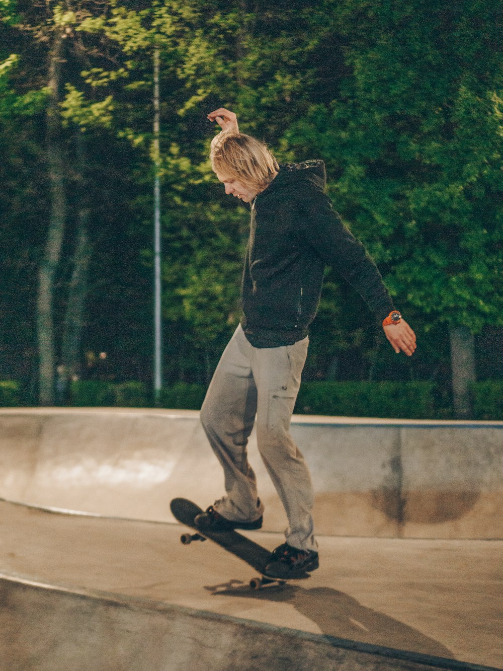 Mann fährt nachts Skateboard auf Betonfeld