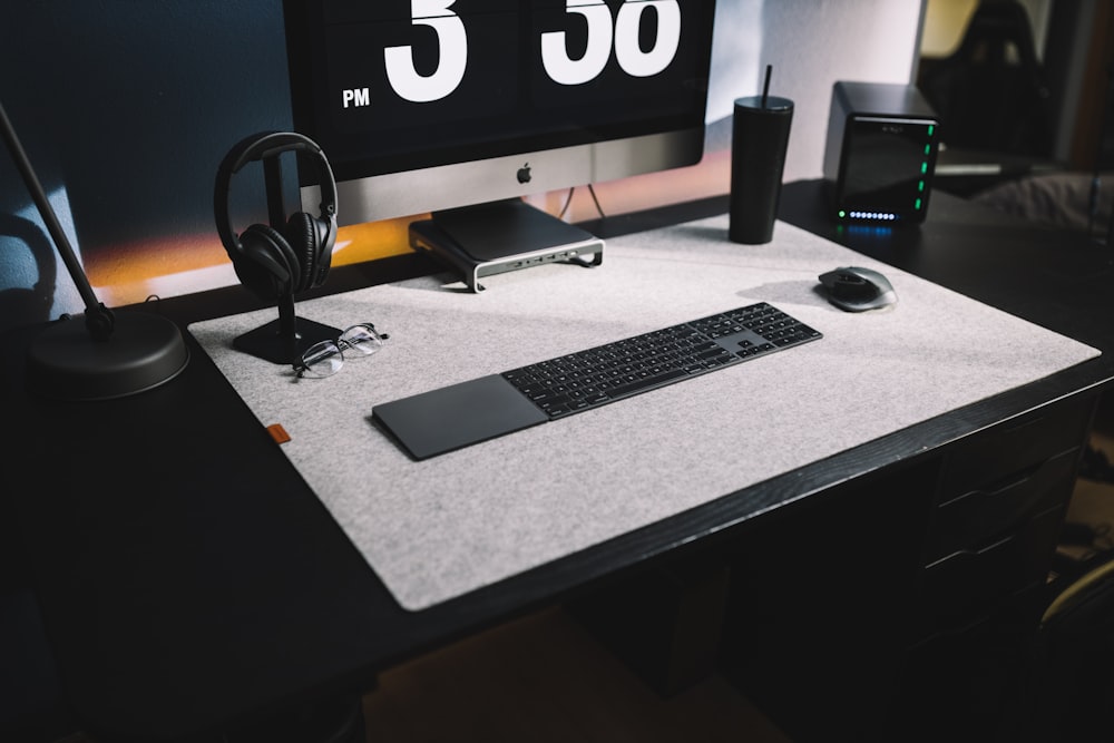 turned-on silver iMac with wireless keyboard on table