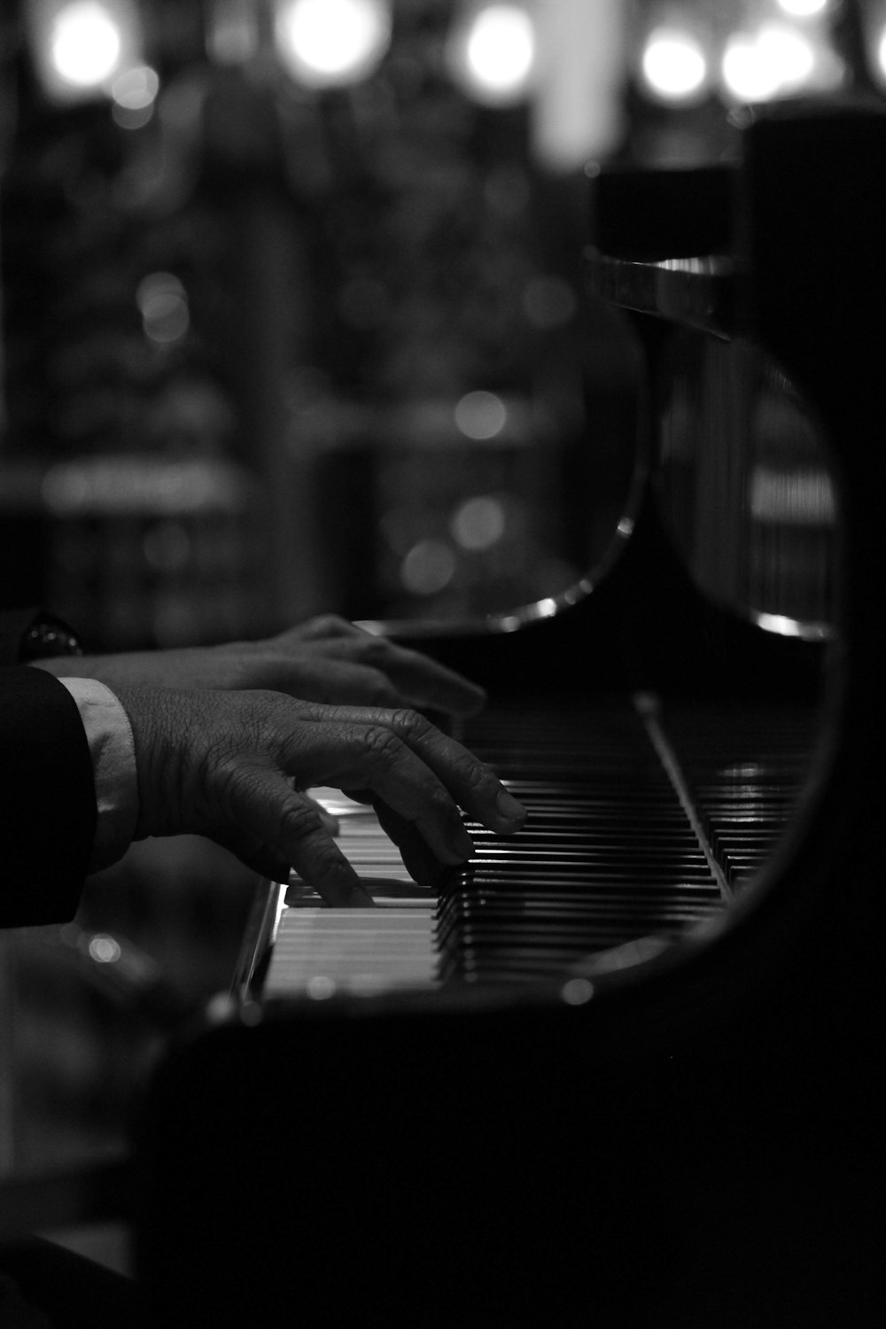 grayscale photography of person playing piano