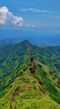 aerial photography of road viewing mountain under blue and white sky during daytime