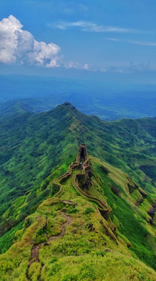 aerial photography of road viewing mountain under blue and white sky during daytime