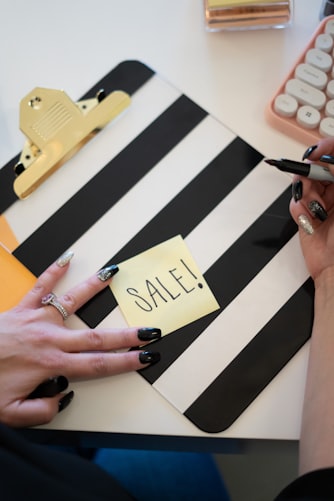 person writing sale sign