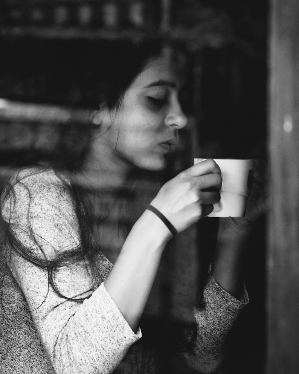 grayscale photo of a woman drinking from a cup