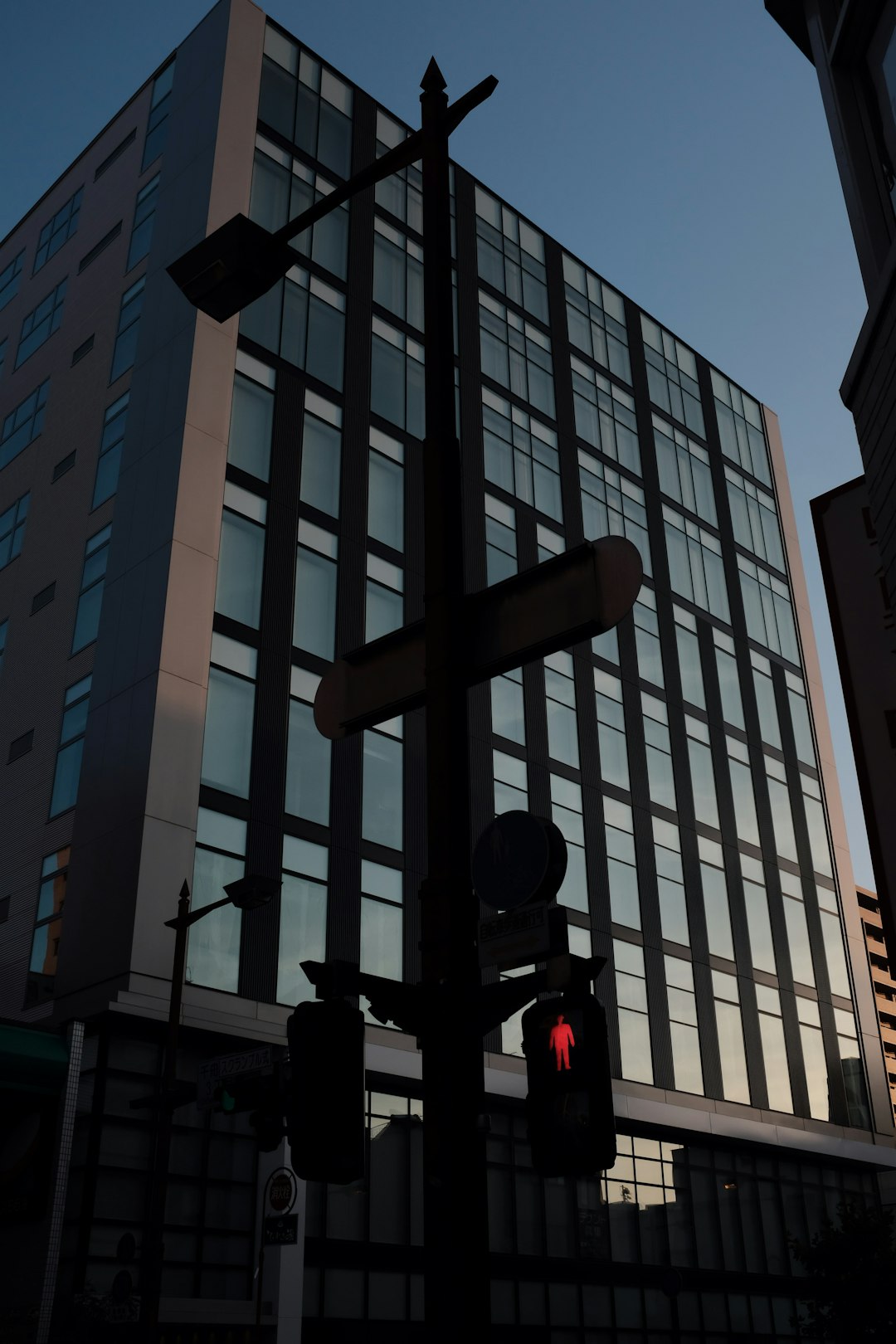 low-angle photography of a traffic light and high-rise glass building