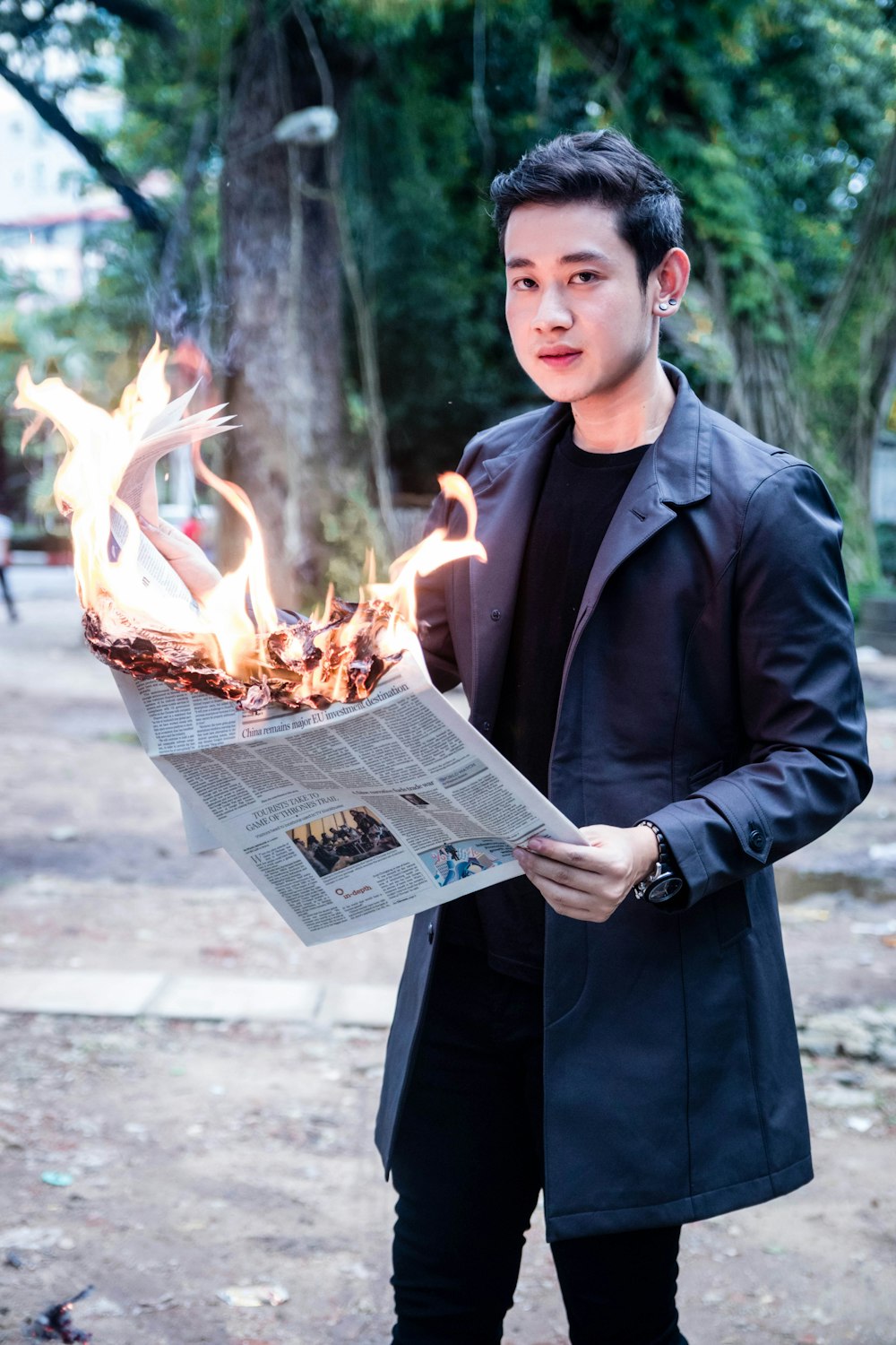 man holding newspaper in fire