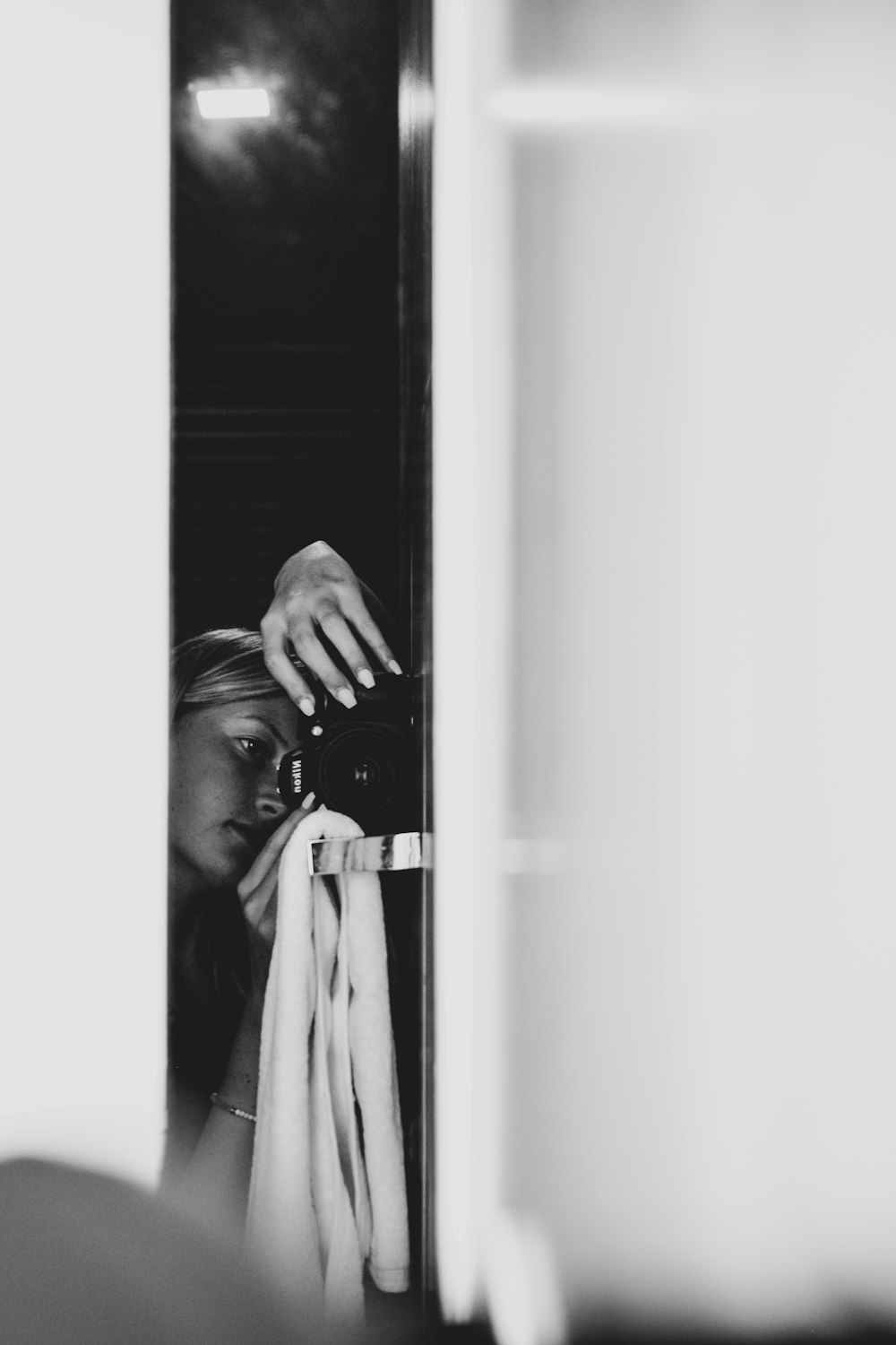 Graustufenfotografie einer Frau, die sich auf Glas stützt