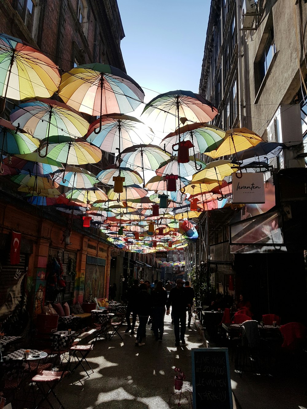 a group of people walking down a street under umbrellas