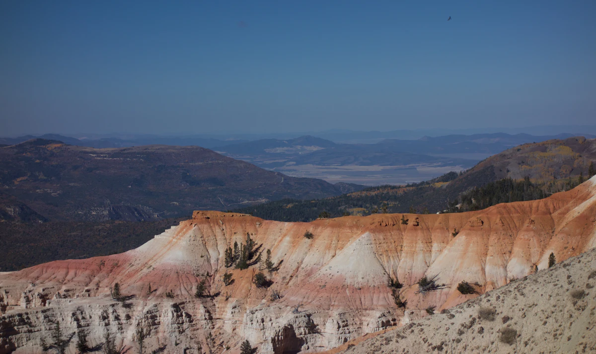 Eroded pink and white cliffs at Cedar Breaks, with a wide valley far below