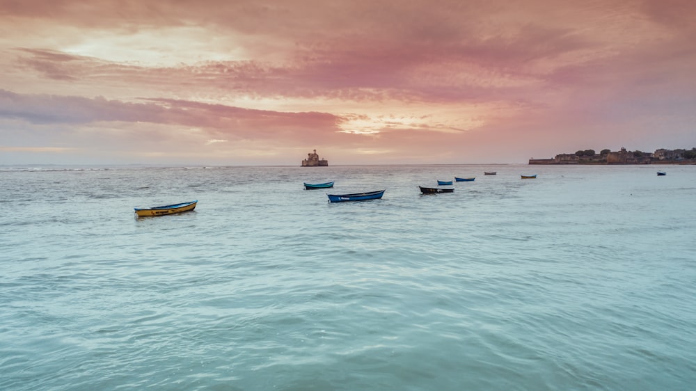 boats on blue body of water viewing mountain during daytime