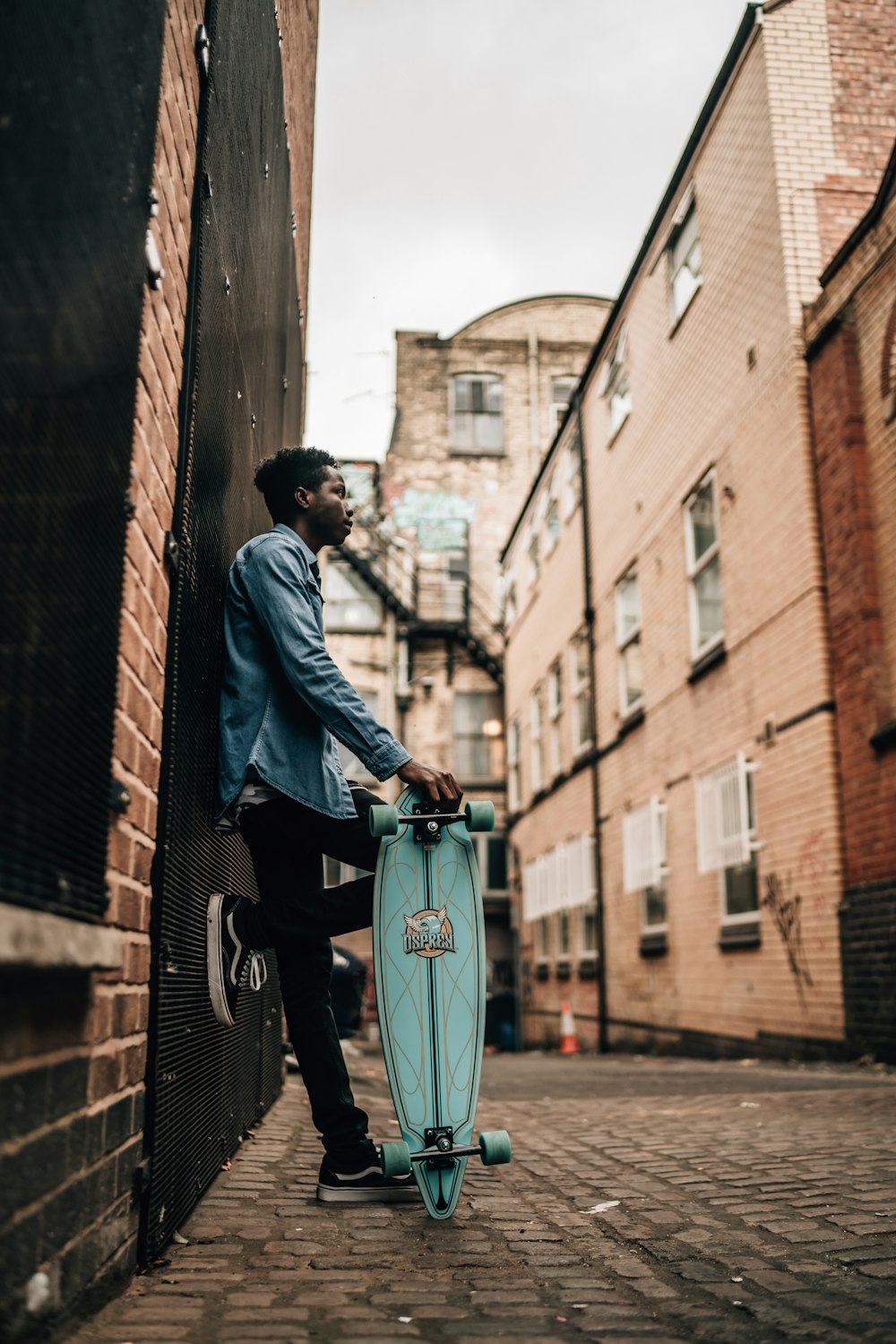 man holding teal longboard