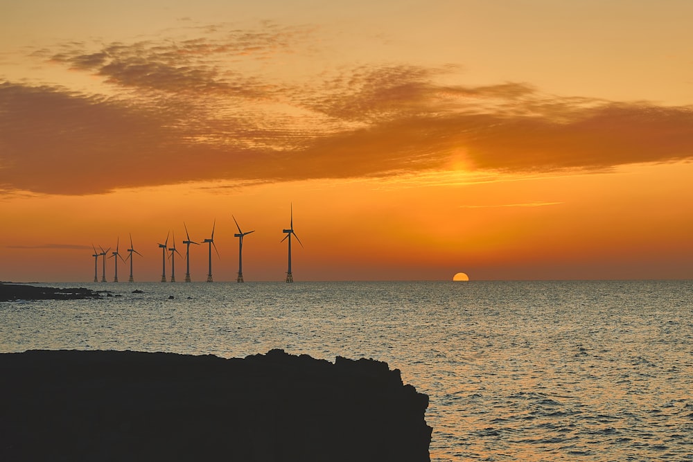 silhouette of wind turbines during golden hour