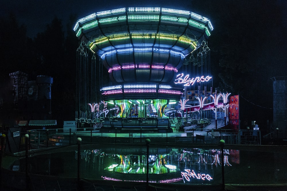 reflection of a building with colorful lights on body of water