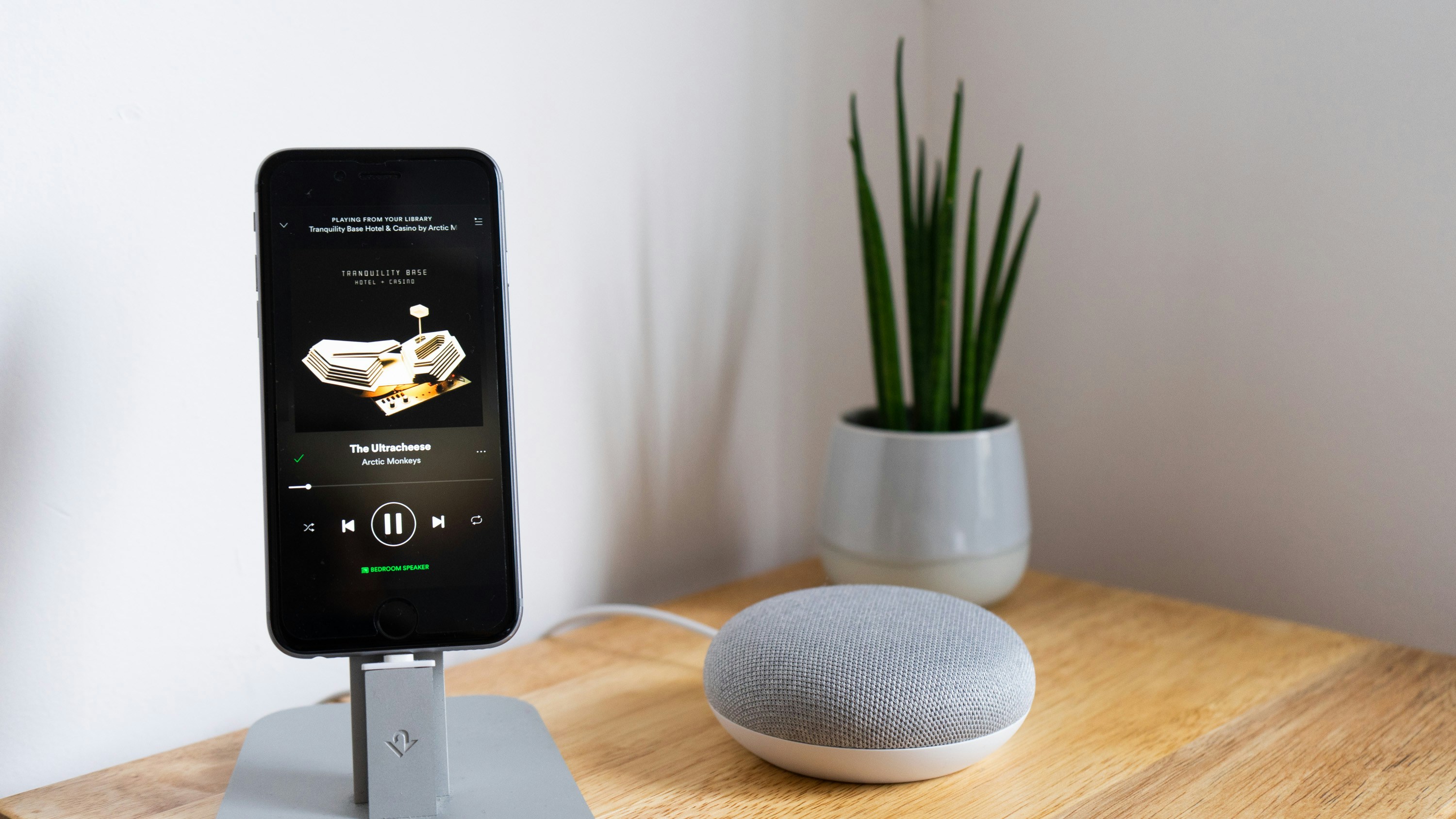 black smartphone playing music while connected to gray corded speaker