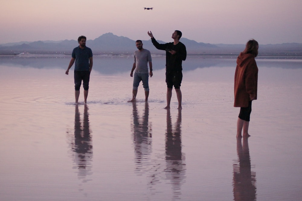 four people standing on wet ground