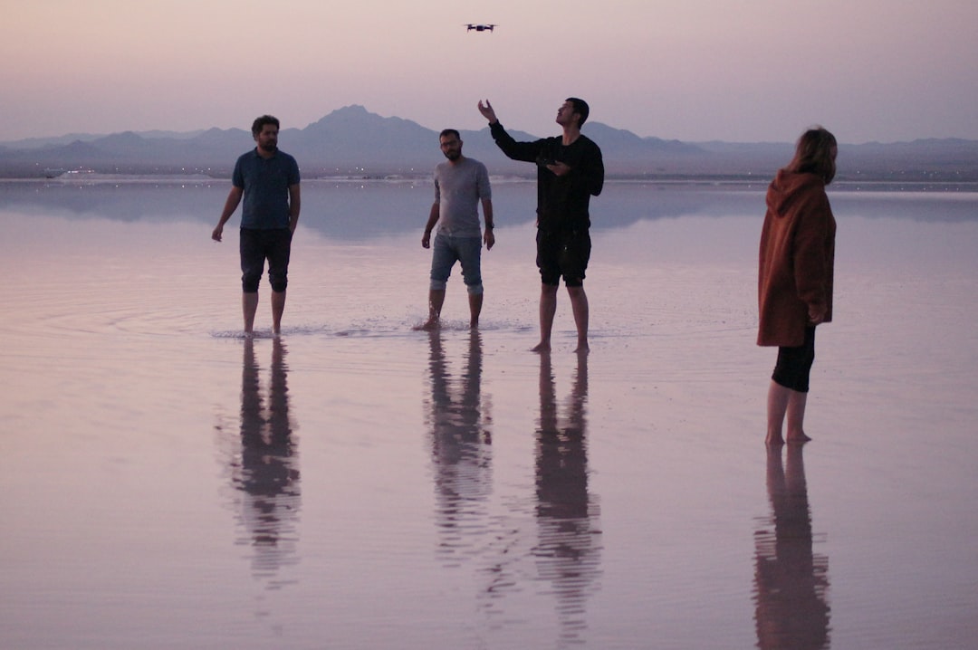 four people standing on wet ground, Biggest natural mirror in Iran.<p></figure>