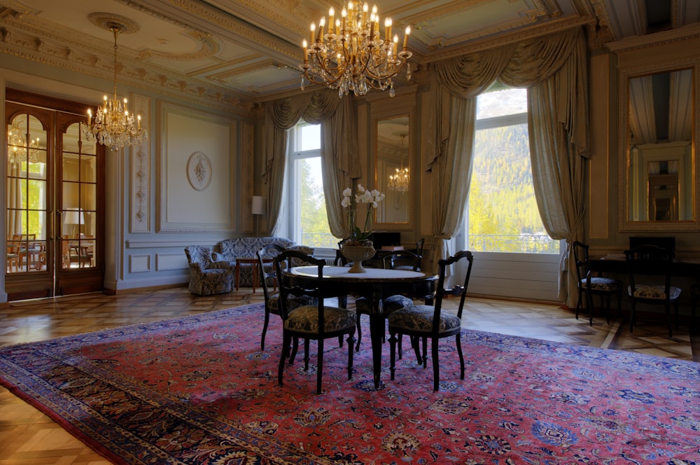 wooden round table and chairs on a red Persian rug