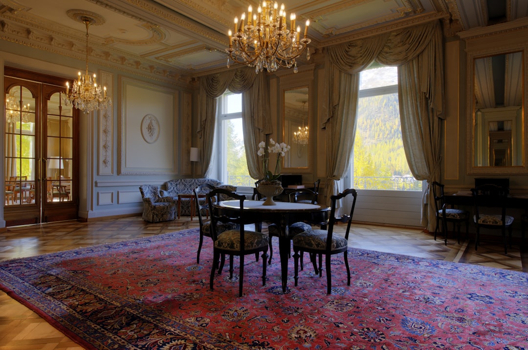 wooden round table and chairs on a red Persian rug,