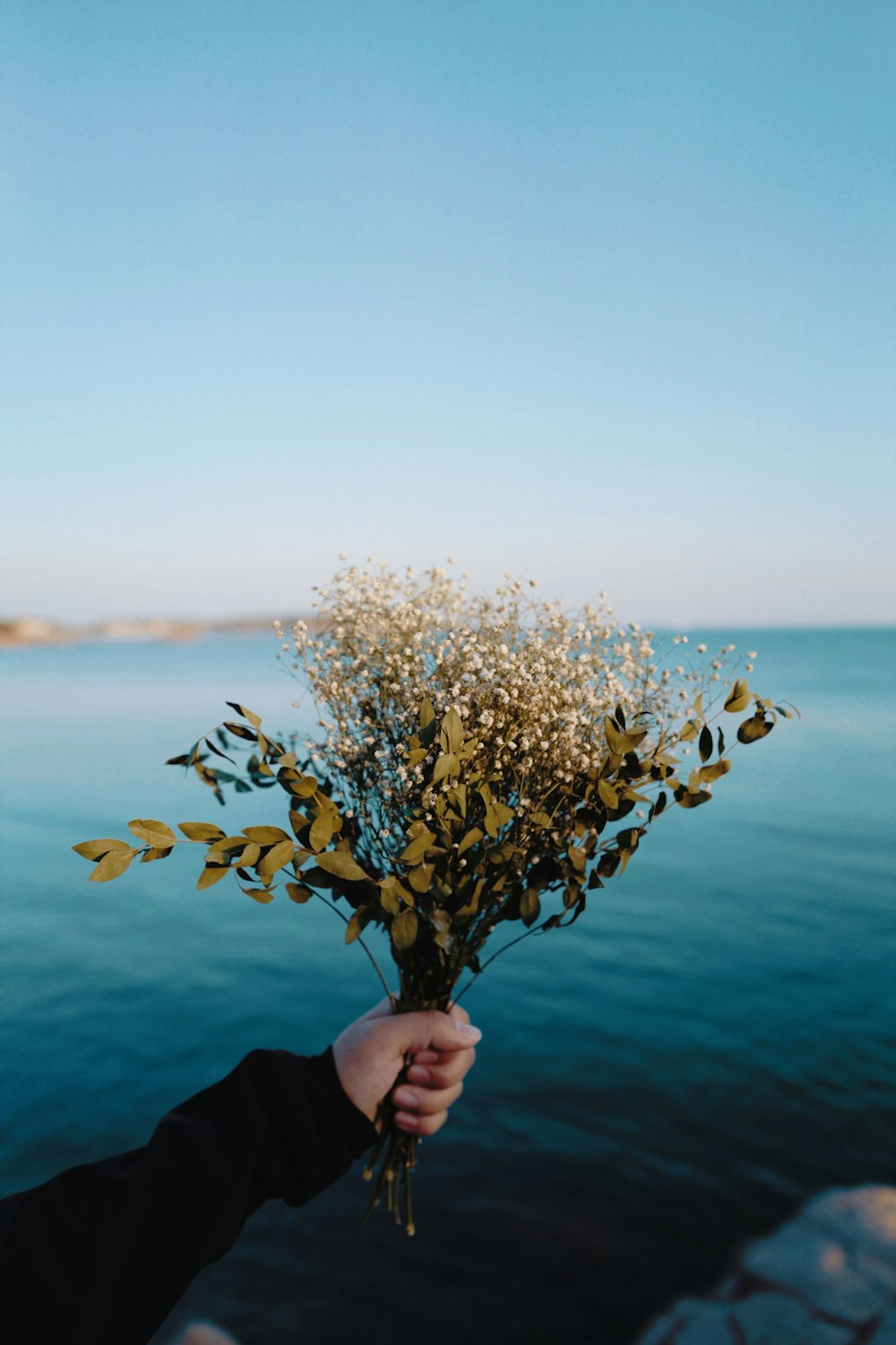 person holding white flower bouquet during daytime