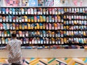 woman crouching in front of display shelf