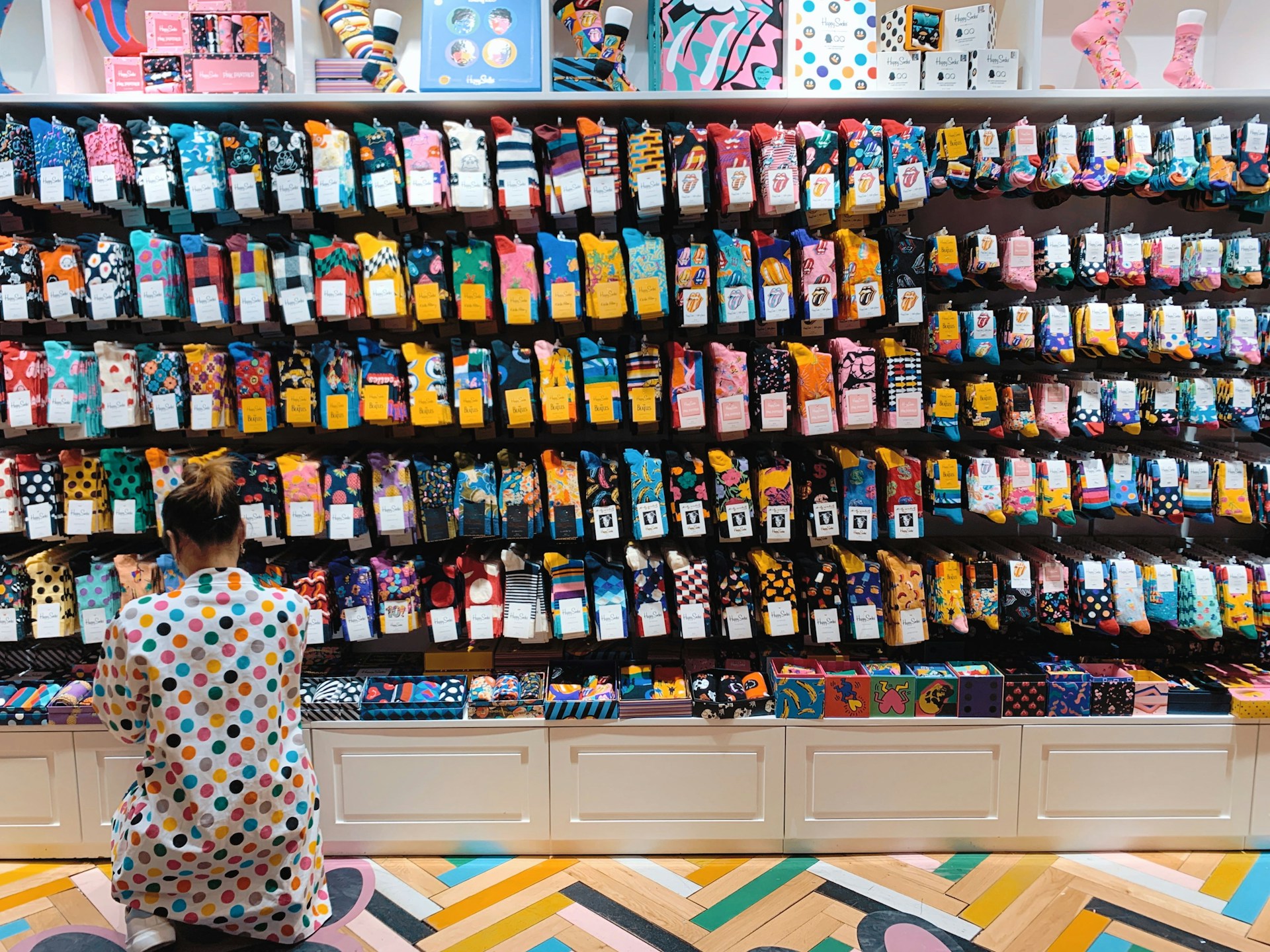 woman crouching in front of display shelf