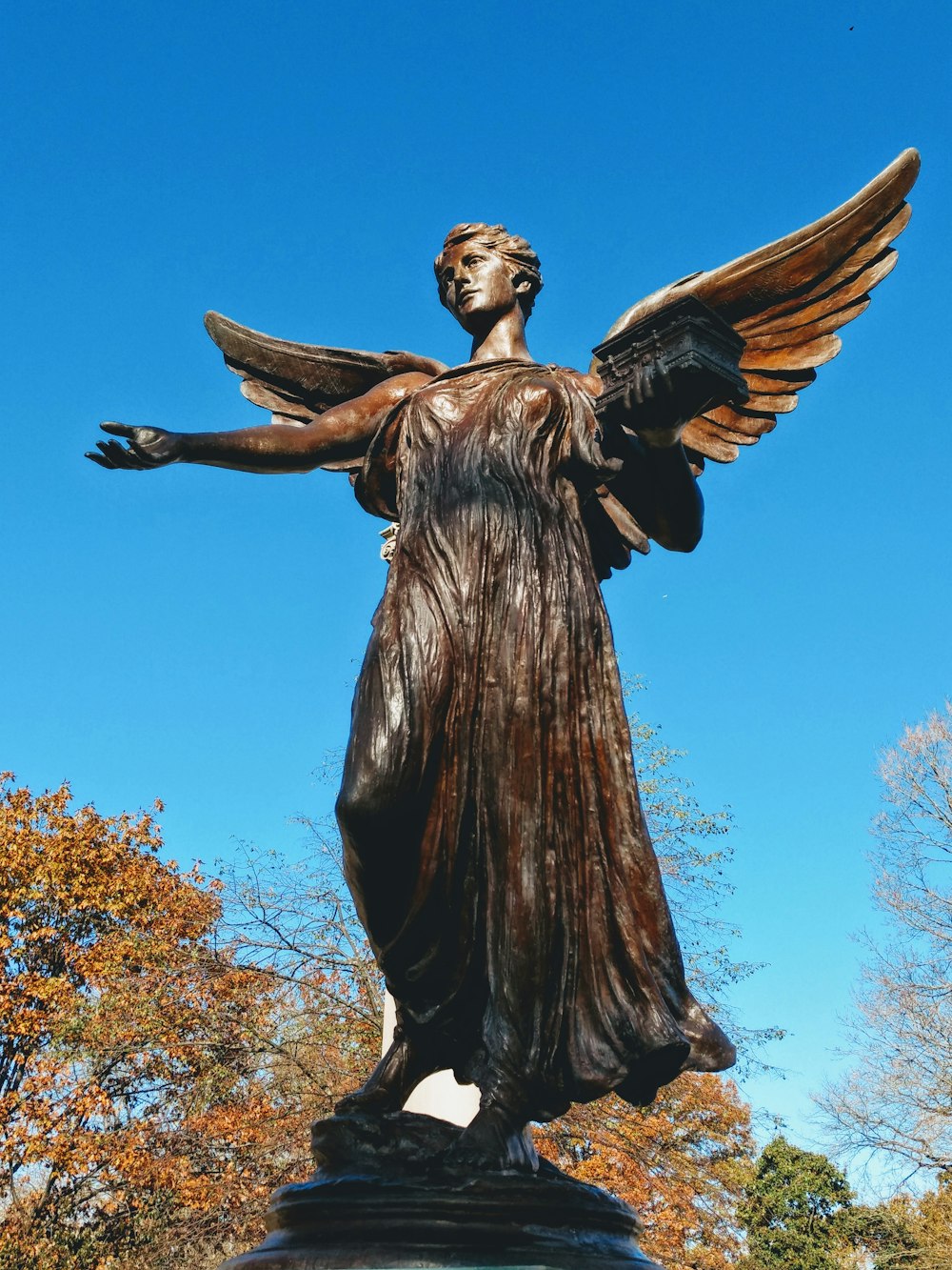 Estatua de ángel femenino bajo un cielo azul tranquilo