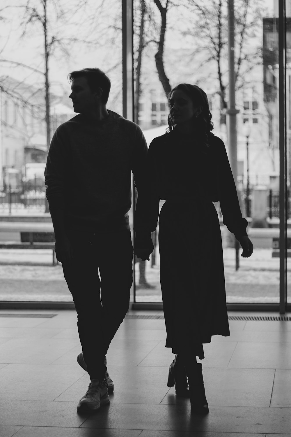 man and woman holding hands while walking