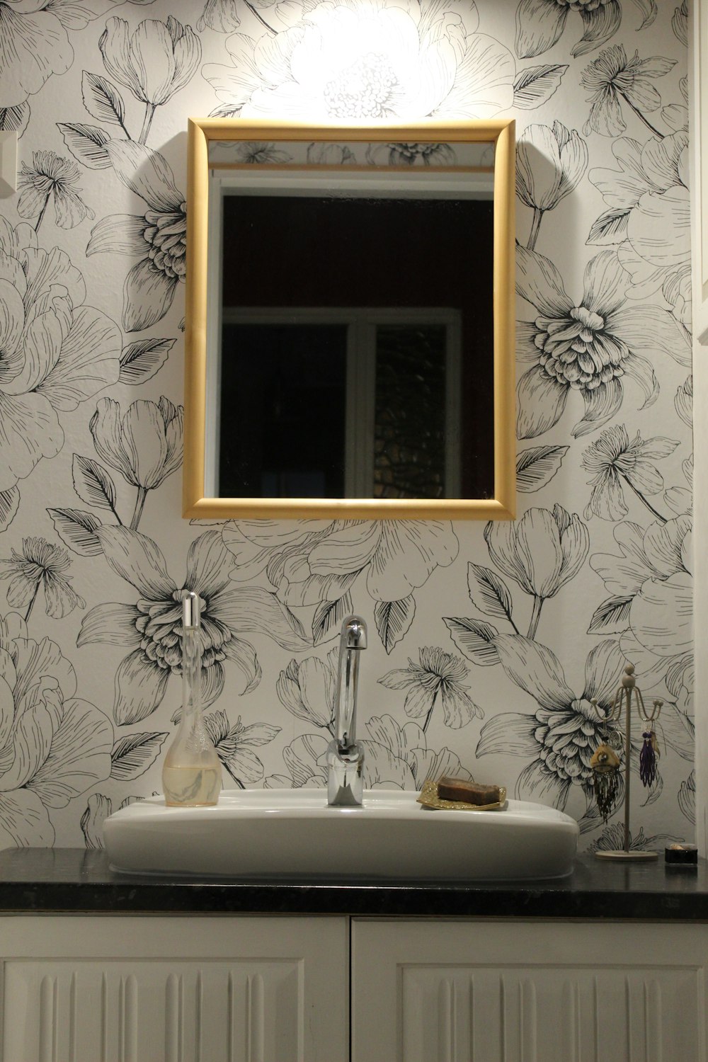 white ceramic sink and gray stainless steel faucet showing open window