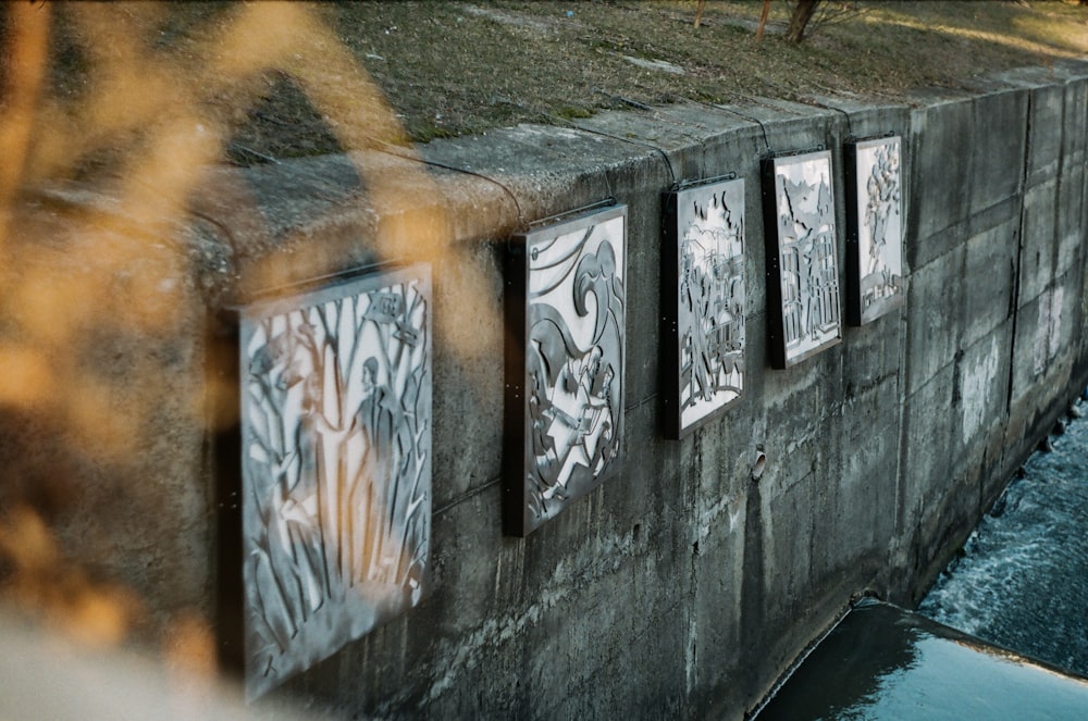 a wall with graffiti on it next to a body of water