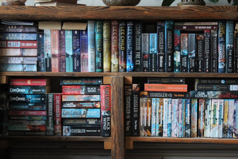 books stacked on a wooden shelving