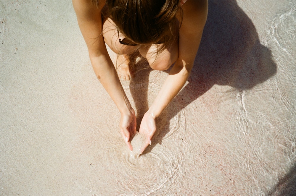 woman holding sand on a beach