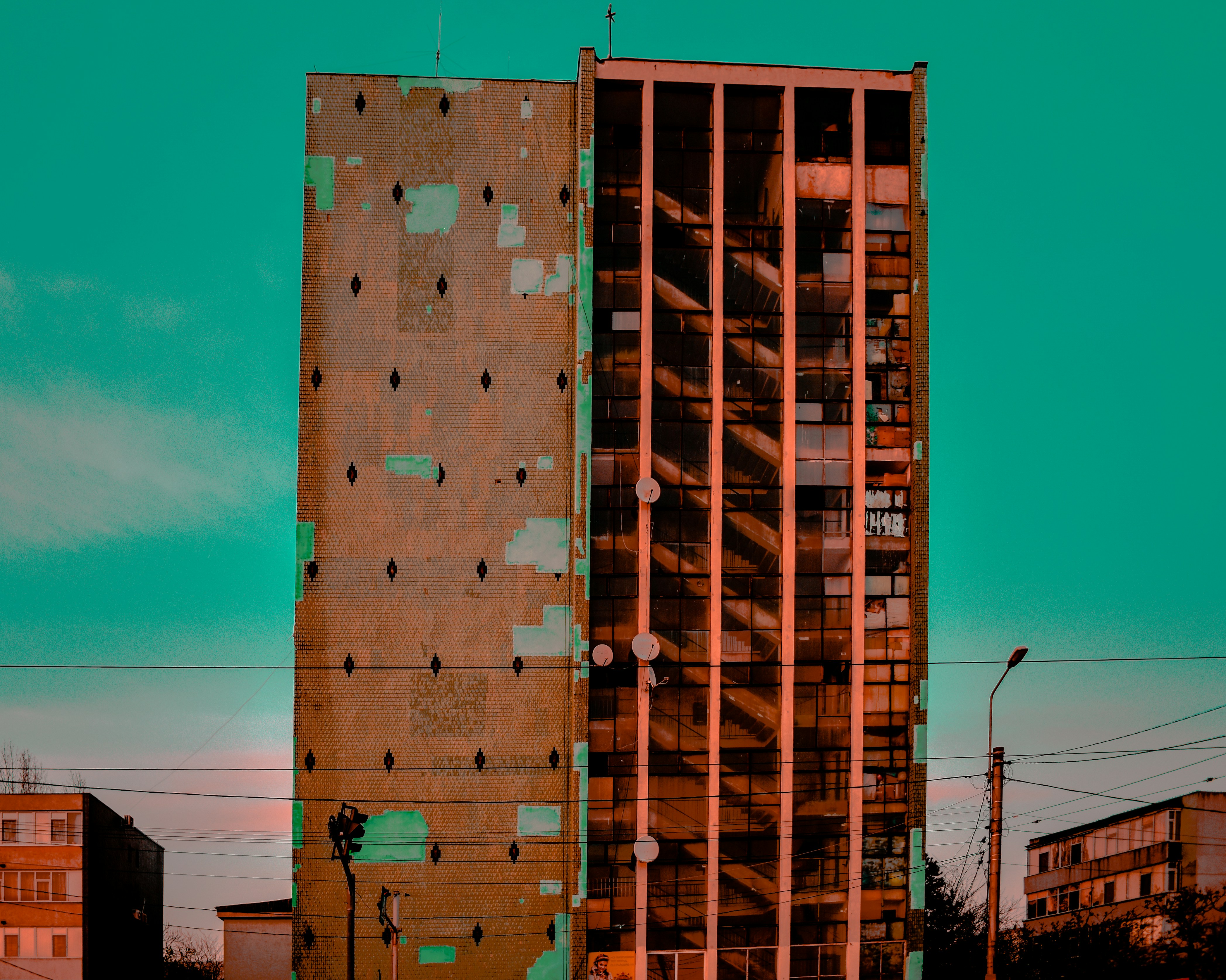 brown concrete high-rise building under a blue calm sky tudor teams background