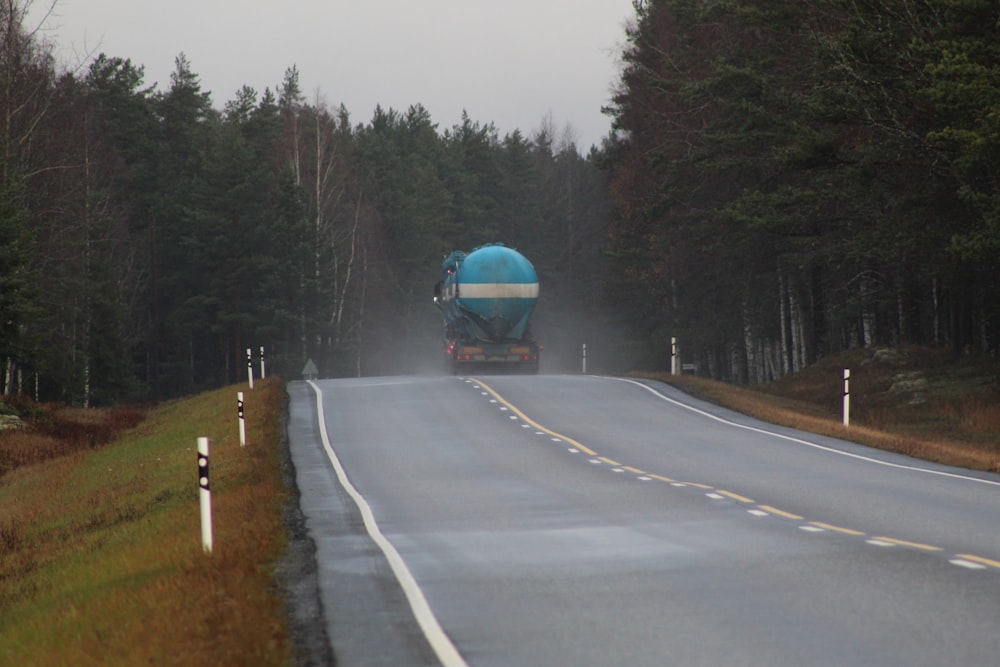 gas truck passing by an asphalt road