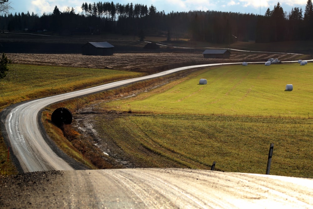 aerial photography of winding road in a green farm