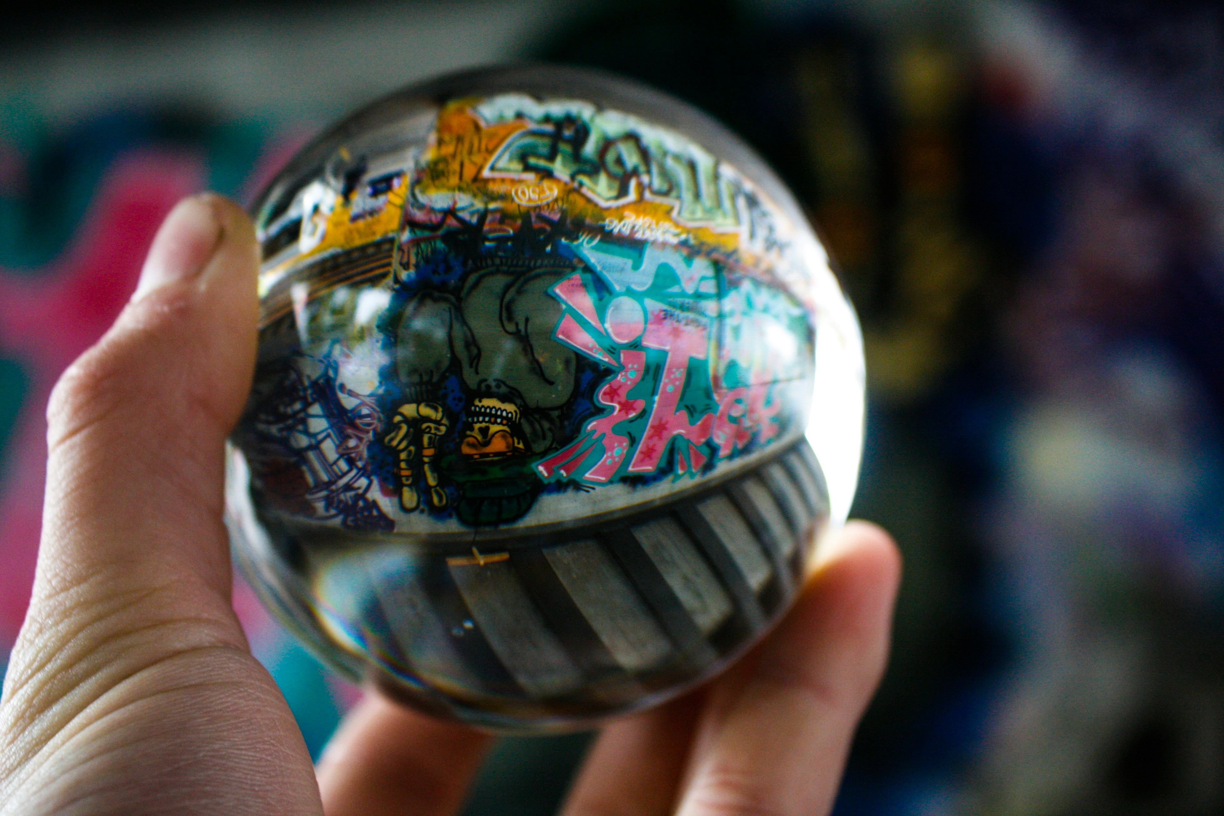 Hand holding a colorful snow globe souvenir featuring a miniature city scene inside