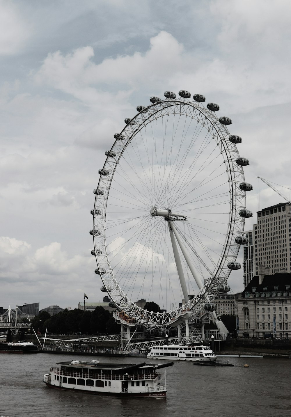 boat passing near Ferris Wheel during daytime