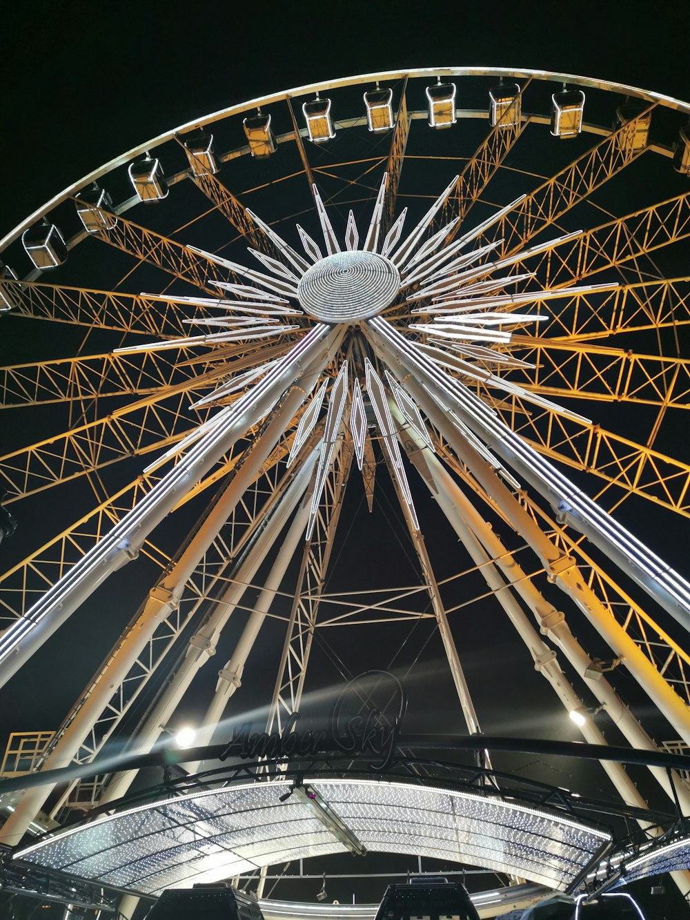 low-angle photo of yellow and grey ferris wheel during night time