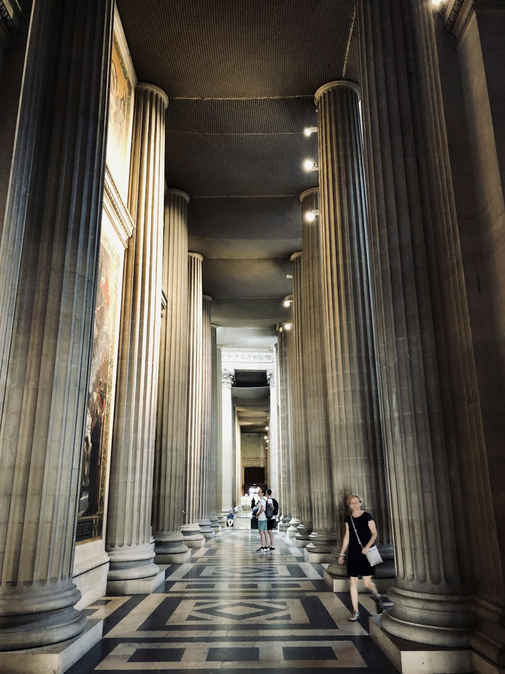 people walking surrounded by concrete pillars