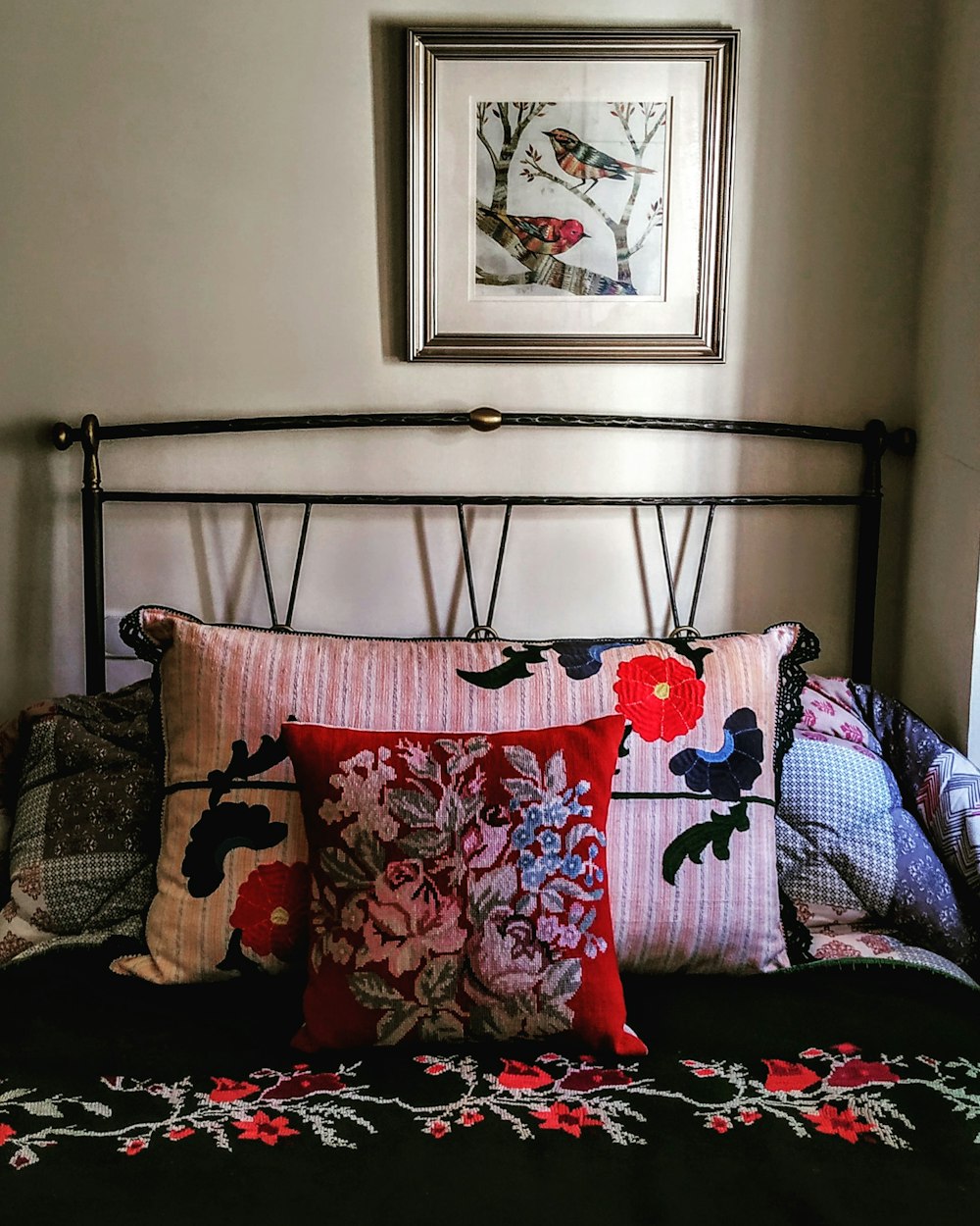 multicolored floral pillows on bed