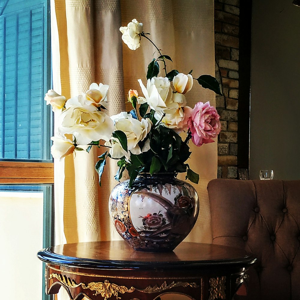 white and pink rose flowers in brown vase on table