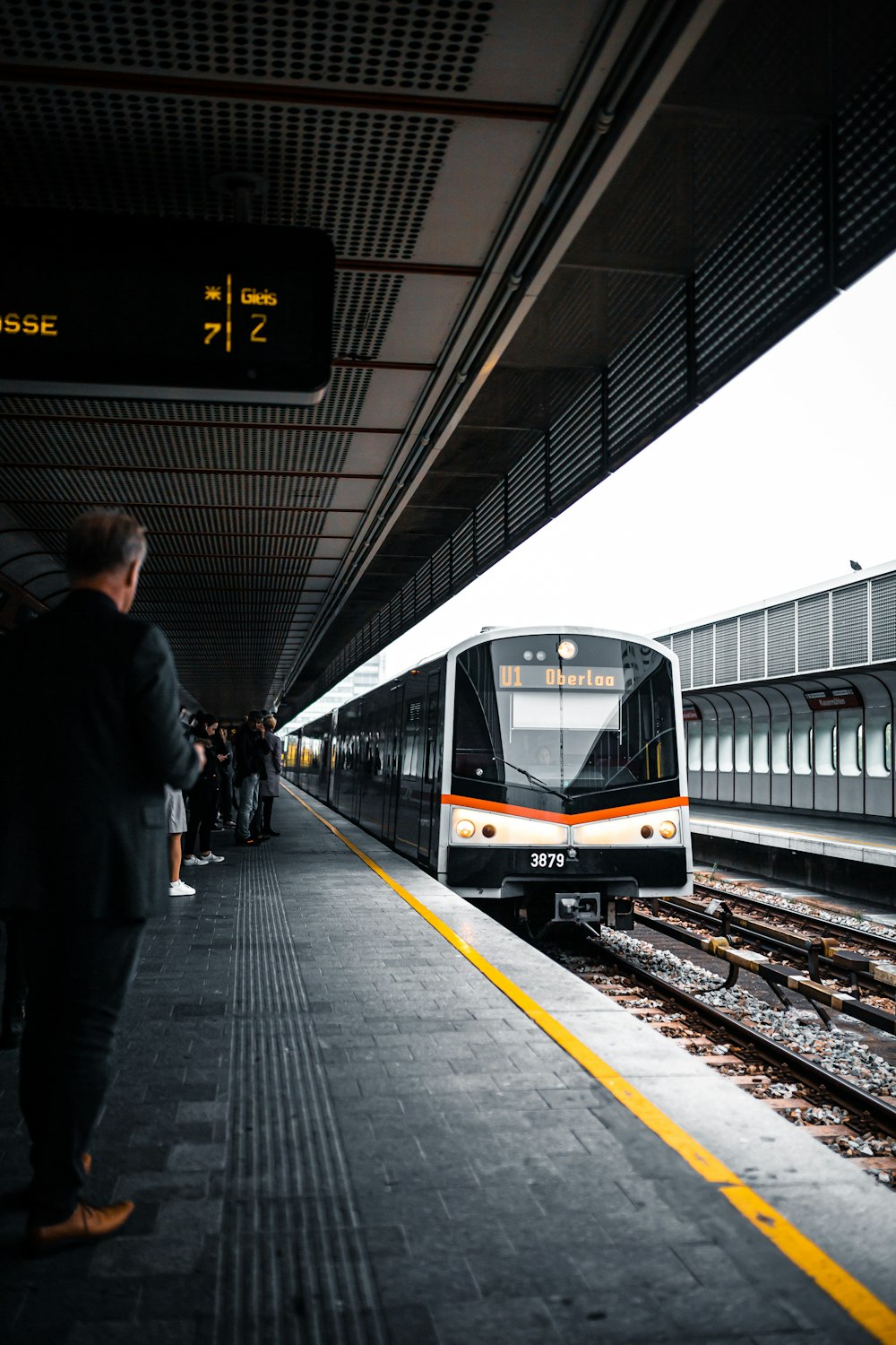 persone in piedi sulla stazione ferroviaria