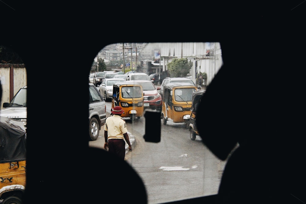 man standing on road and different vehicles on street