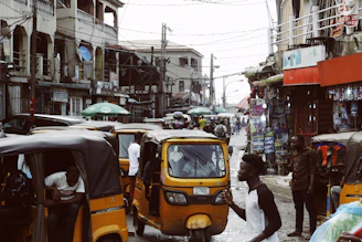 people on street and different vehicles near buildings during daytime