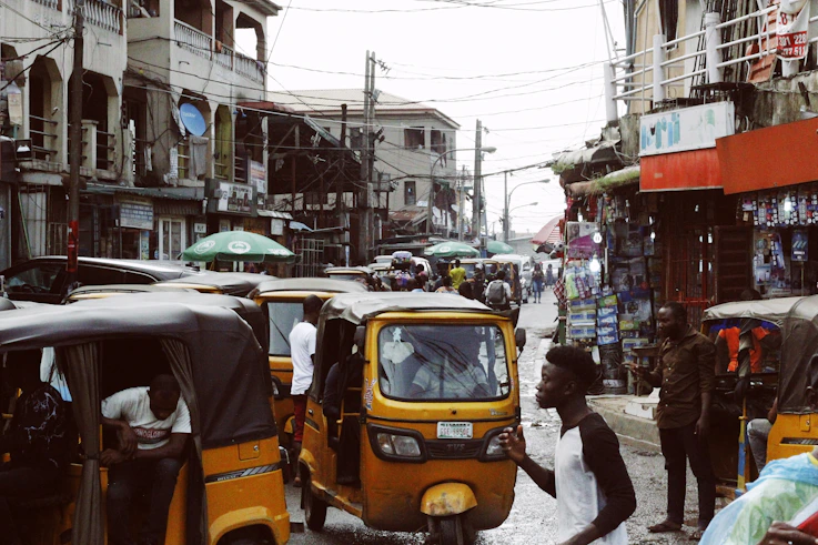 people on street and different vehicles near buildings during daytime