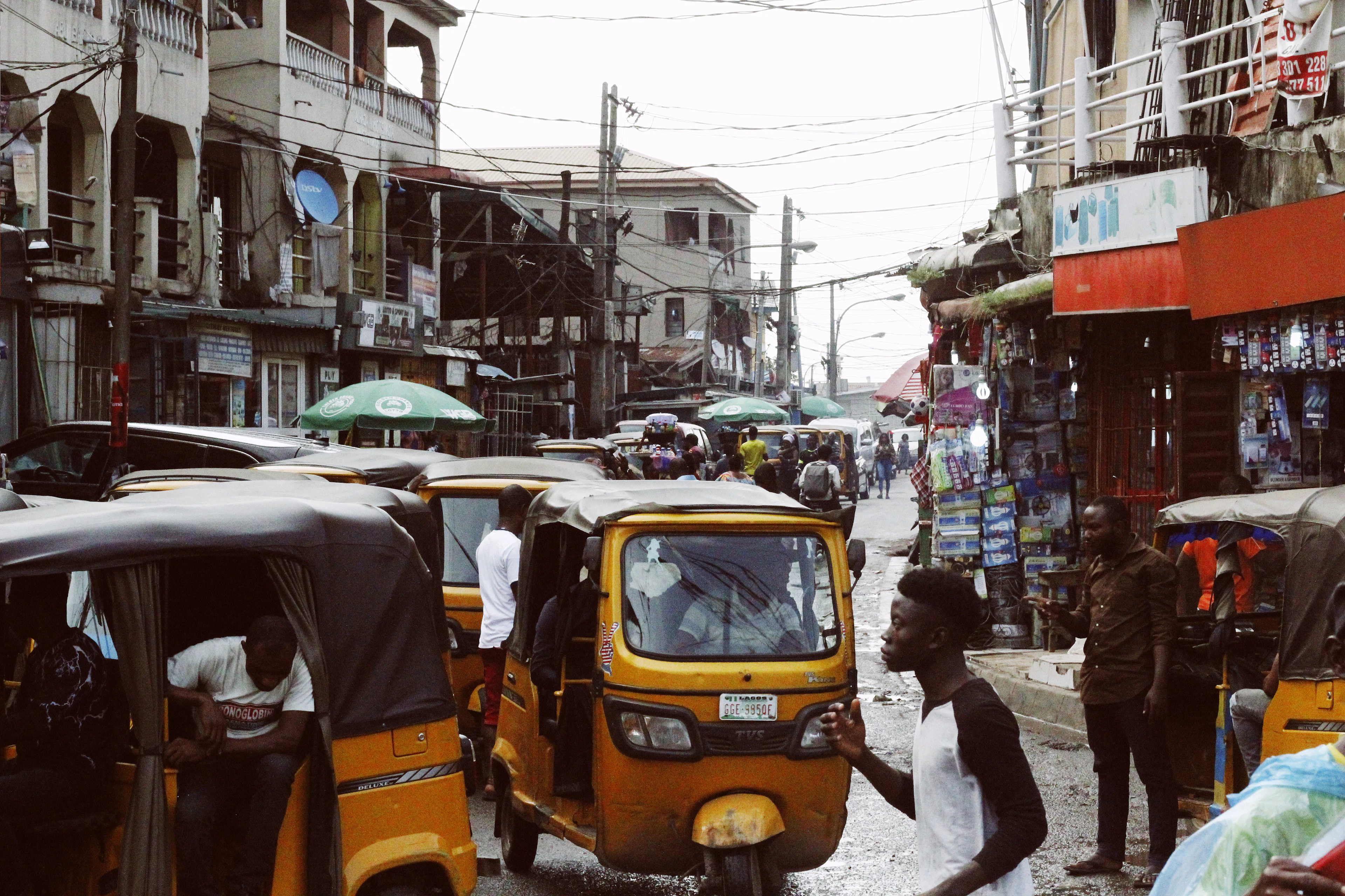 A busy Lagos street with yellow tricycles